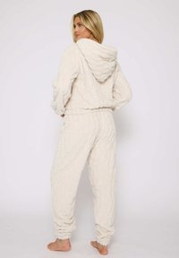 Set di loungewear in peluche color crema, composto da una felpa con cappuccio e zip dal finish testurizzato e pantaloni fitted abbinati con polsini a coste.