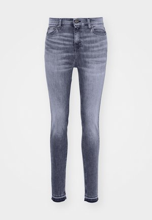 Jeans skinny din denim gri deschis cu talie înaltă. Prezintă cinci buzunare, un pas cu curea și un închidere cu nasture metalic. Marginile distruse la glezne.