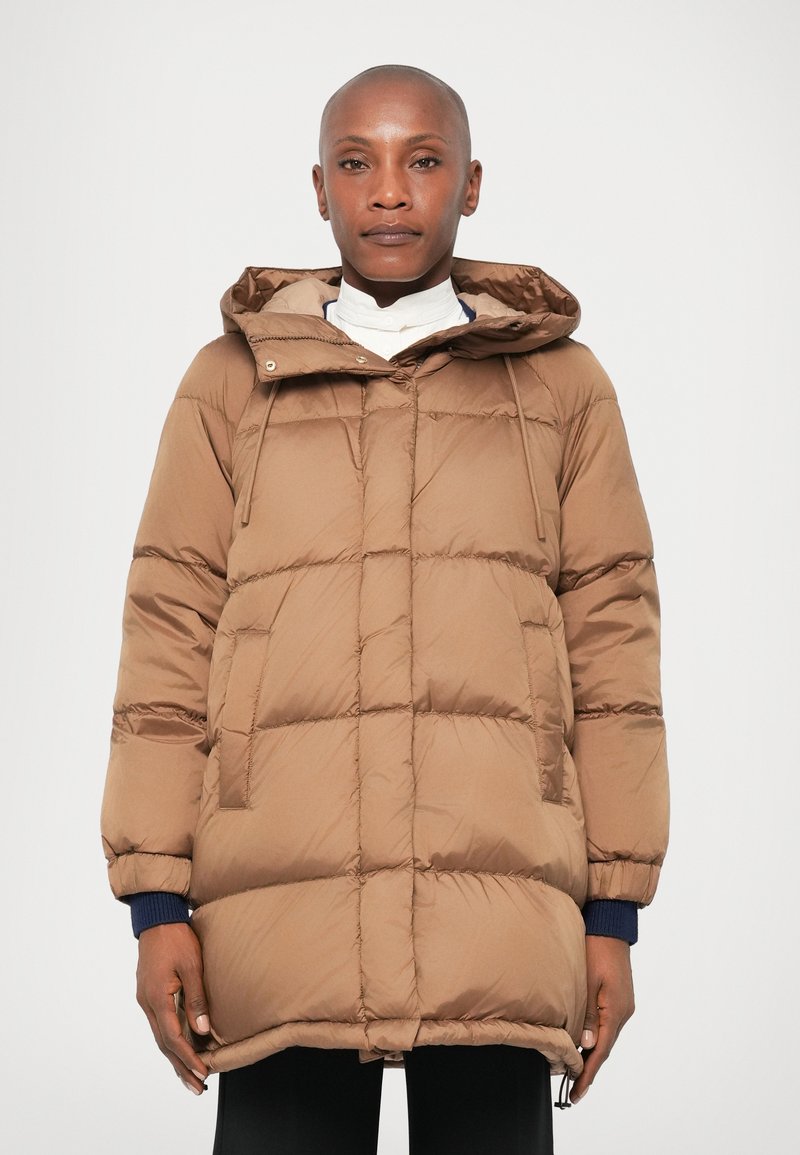 Casaco puffer castanho com capuz, apresentando um design acolchoado, punhos elásticos e dois bolsos frontais. O material parece suave e isolante.