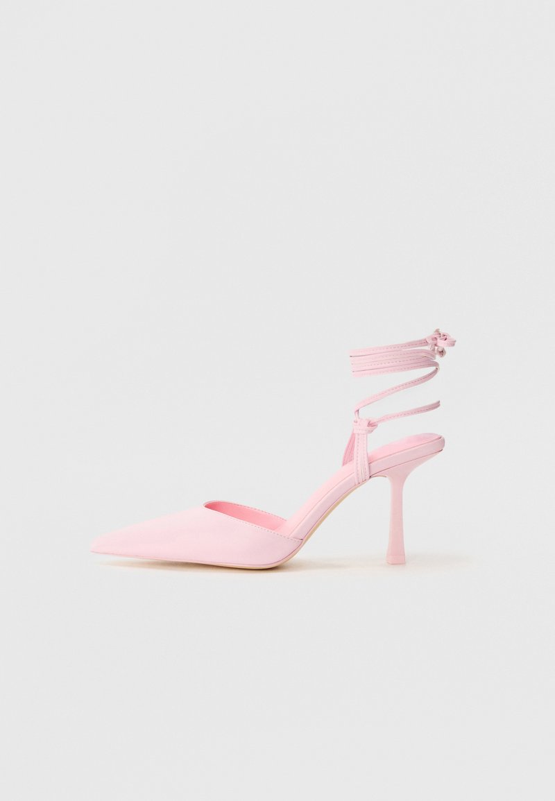 Růžové lodičky na vysokém podpatku s špičatou špičkou, saténovým povrchováním a kotníkovým páskem se zkříženými detaily. Elegantní silueta a tenký podpatek.