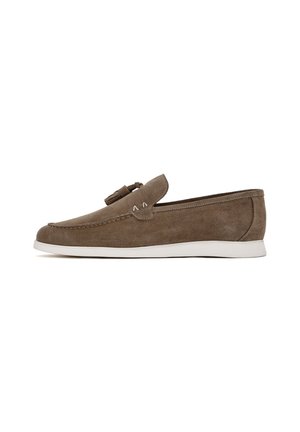 Suede loafers in light brown with a white rubber sole. Features a decorative tassel and stitching details along the edges. Side profile view.