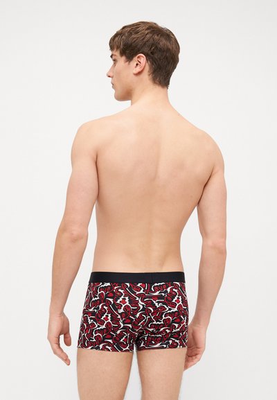 Boxers noirs à taille élastique avec un motif abstrait sur le thème de l'amour en rouge et blanc. Le tissu semble doux avec un ajustement près du corps, présentant une longueur jusqu'au milieu de la cuisse.