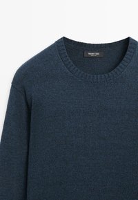 Maglione blu scuro lavorato a maglia con scollo girocollo a coste e tessuto morbido. Etichetta con la scritta "Massimo Dutti." Design classico, ideale per sovrapposizioni.