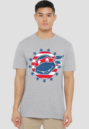 Graues Baumwoll-T-Shirt mit einem blauen und roten kreisförmigen Design, das eine Schildkrötenfigur und Sterne zeigt, im lässigen Rundhalsausschnitt-Stil.