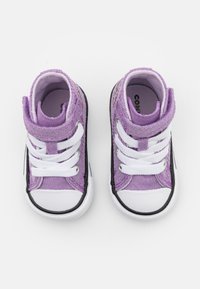 Fialové vysoké tenisky s bílými tkaničkami, černou gumovou podrážkou a texturovaným povrchem. Mají polstrovaný límec a logo na stranách.