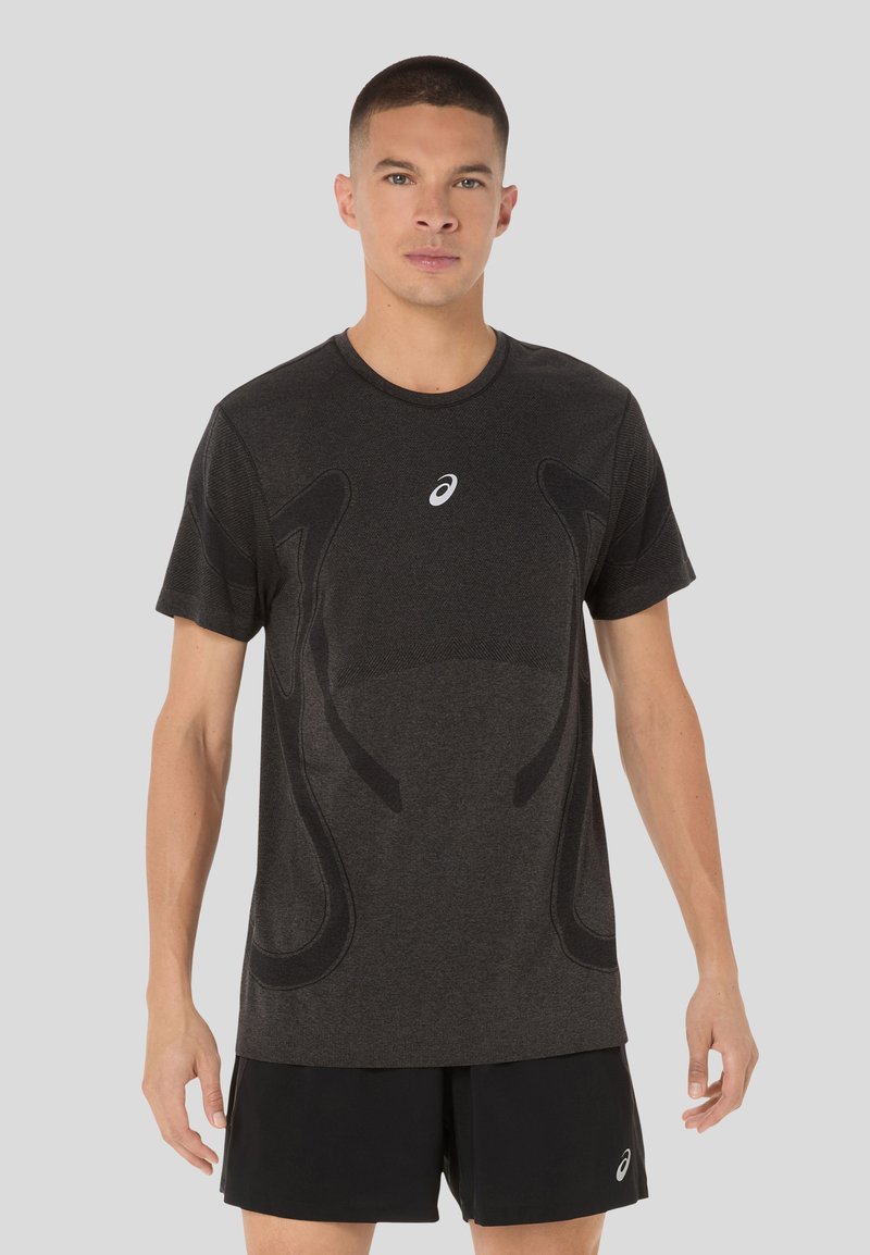 Schwarzes sportliches T-Shirt mit kurzen Ärmeln, ausgestattet mit einem strukturierten Design und einem weißen Logo auf der Brust. Hergestellt aus feuchtigkeitsableitendem Material.