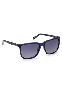 Gafas de sol cuadradas con marco mate en color azul marino y lentes degradados de color púrpura oscuro. Presentan acentos metálicos en las bisagras y brazos rectos y delgados.
