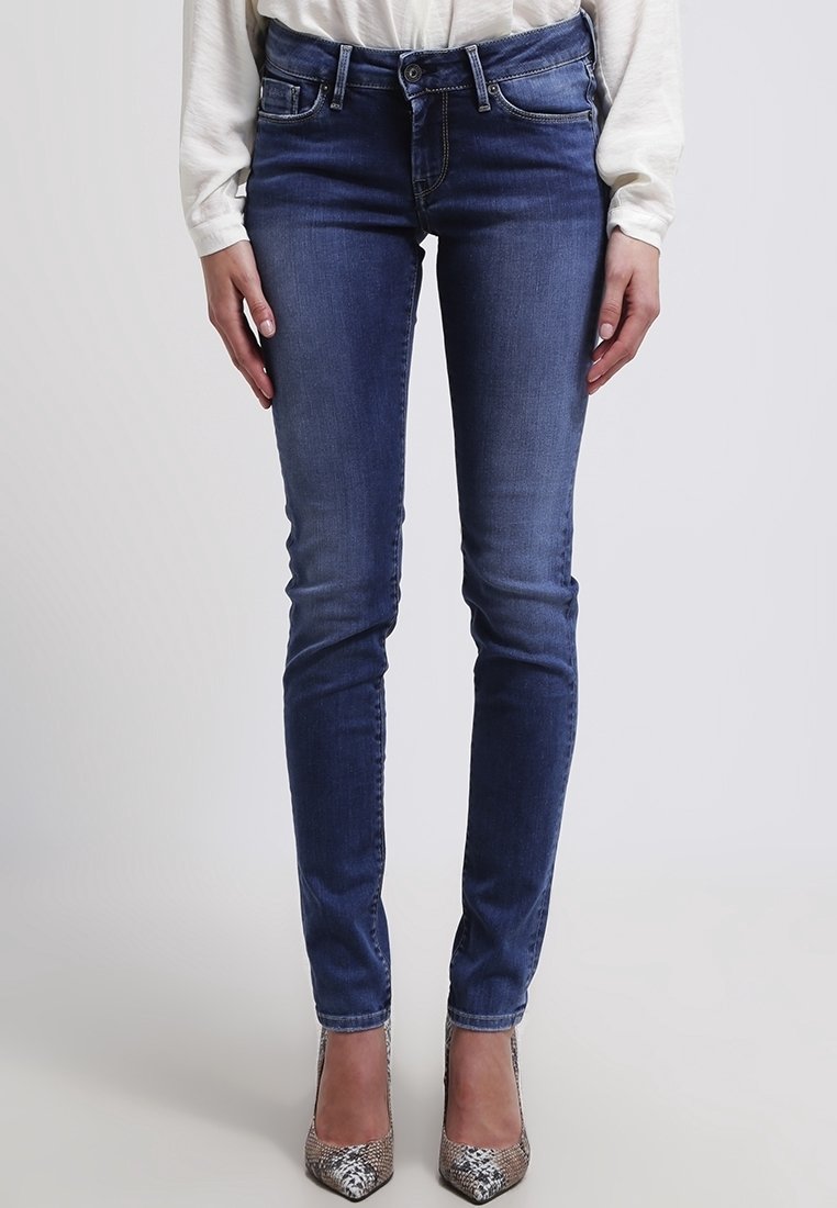 Jeans ajustados en denim azul oscuro con un ligero desgastado, presentando una cinturilla estándar, bolsillos delanteros y un diseño de corte entallado.