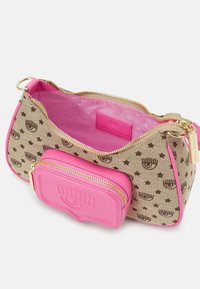 Hnědá plátěná taška se vzorem zlatých hvězd, růžovými akcenty a zlatým zipem. Obsahuje malý růžový sáček připojený na zip. Vnitřek je růžový.