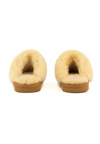 Natuurlijke schapenleren slippers met een zachte, pluche textuur, ronde open achterkant en een tan rubberen zool. Gezellig en warm ontwerp.