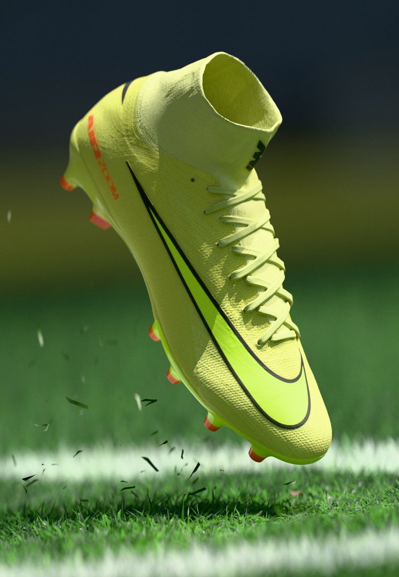 Botín de fútbol de caña alta color amarillo brillante con el logo negro de la marca, levantando hierba en un campo de fútbol verde cerca de la línea blanca.
