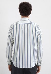 Gestreifte Langarmbluse in Weiß und Blau, mit einem Button-Down-Kragen, geradem Saum und Manschetten mit kontrastierenden Streifen. Aus Baumwollmaterial.