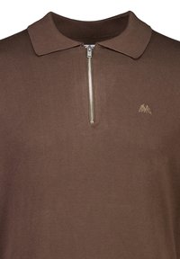 Brun stickad polo skjorta med dragkedja, med en platt krage och en diskret broderad logotyp på bröstet. Slät textur, avslappnad design.