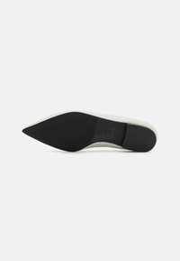 Chaussure à bout pointu avec un dessus blanc lisse et une semelle en caoutchouc noir solide. Design épuré avec une esthétique minimaliste.