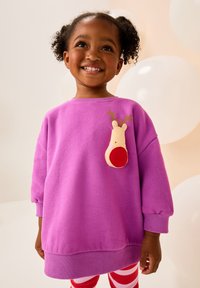 Paarse trui met geribbelde boorden en zoom, met een rendierenapplicatie met rode neus en gewei. Gestreepte legging in rood en wit.