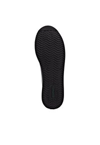 Black rubber shoe sole featuring a herringbone tread pattern, with a molded logo at the center and rounded heel for stability.