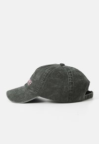 Casquette de baseball en coton gris foncé avec une visière incurvée, une texture subtile et un logo rose brodé à l'avant. Bride ajustable à l'arrière.