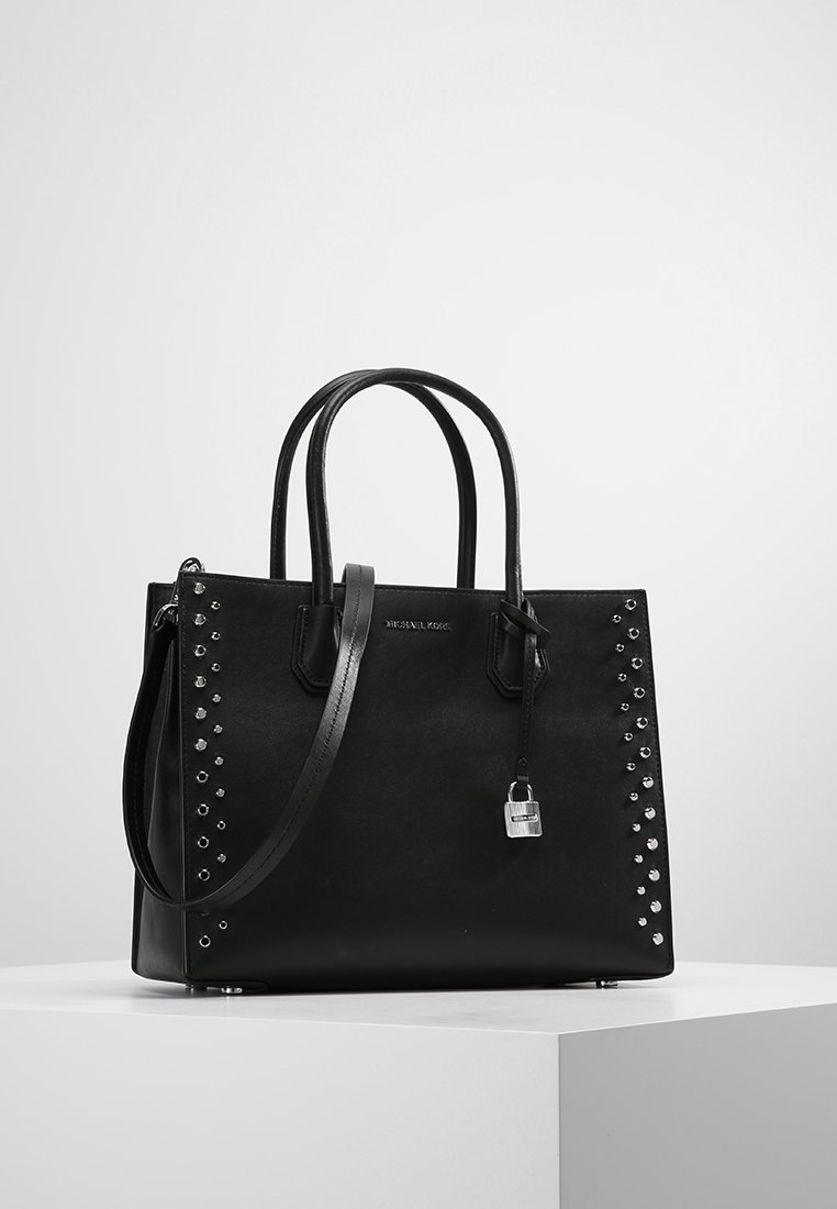 Sac à main en cuir noir avec deux poignées, une bandoulière, des clous argentés sur les côtés et un petit cadenas argenté suspendu à l'avant.