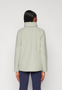 Light gray, long-sleeved jacket with a high collar, smooth texture, visible stitching, and a straight hem. The wearer is facing away.