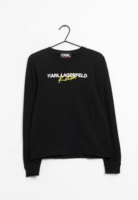 Felpa nera a maniche lunghe appesa con "KARL LAGERFELD" in bianco e "Kara" in giallo scritto a mano sul davanti.