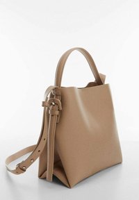 Beige syntetisk læder håndtaske med en struktureret form, top-håndtag og justerbar skulderrem, der har en glat tekstur og et minimalt design.