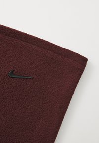 Burgunderfleece-stoff med teksturert overflate, med en svart brodert Nike-logo på brystområdet. Rene kanter og sømmer.