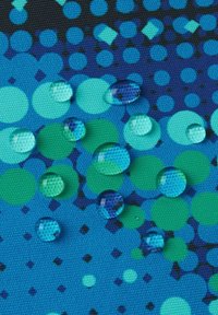 Textured fabric in shades of blue and green features circular patterns, with droplets of water resting on the surface.