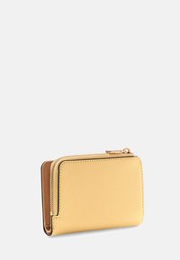 Portefeuille jaune texturé en matériau synthétique, avec une fermeture éclair et un intérieur lisse de couleur beige contrastante. Forme rectangulaire avec des bords arrondis.