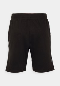 Pantalones cortos casuales negros con cintura elástica y un sutil detalle en los paneles laterales, exhibidos sobre un fondo blanco liso.