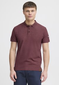 Bordeaux polo shirt lavet af struktureret bomuld, med en to-knaps lukning, korte ærmer og en logo-detalje på ærmet.