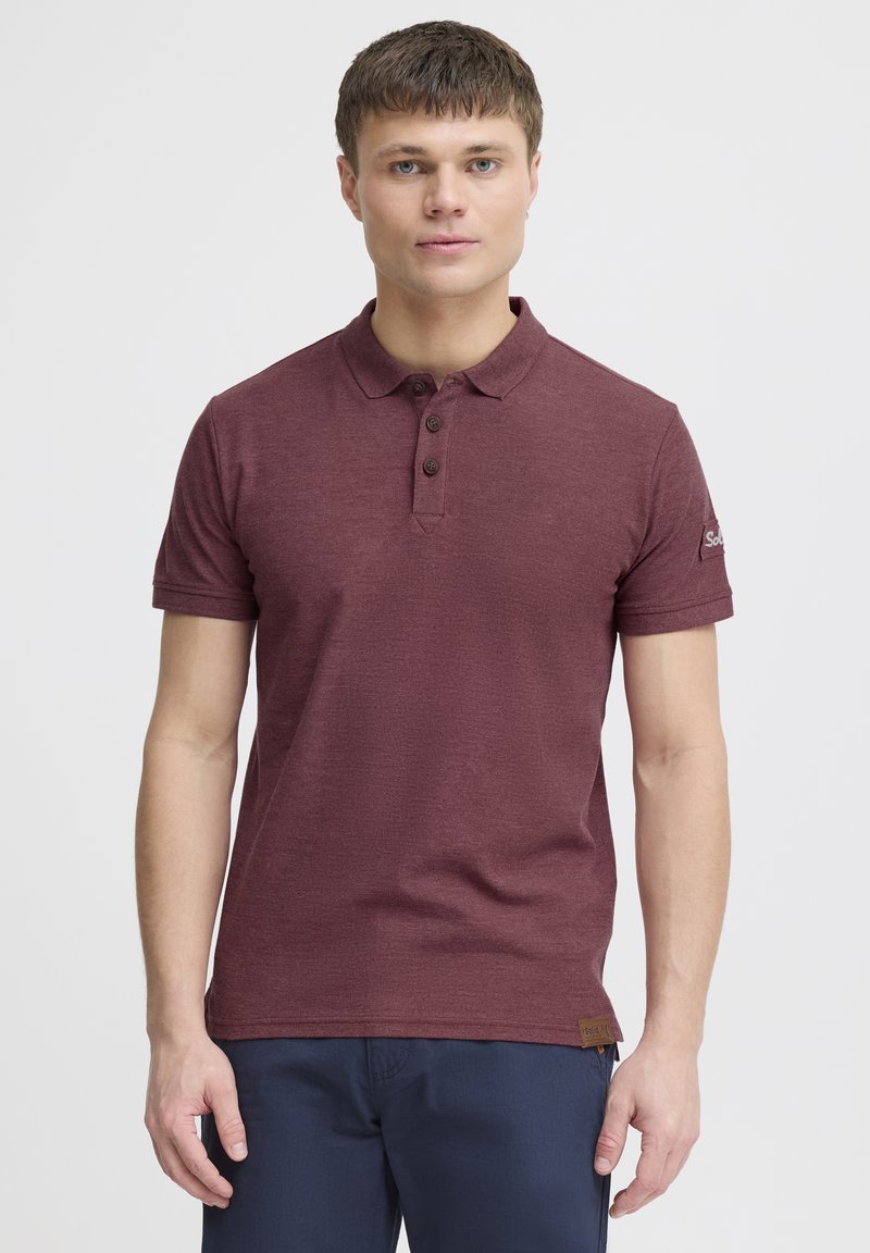 Bordeaux polo shirt lavet af struktureret bomuld, med en to-knaps lukning, korte ærmer og en logo-detalje på ærmet.