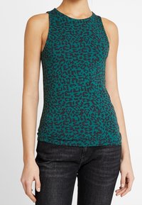 Bezrukávý tyrkysový top s potiskem černého leopardího vzoru, vyrobený z lehkého materiálu, s kulatým výstřihem a přiléhavým střihem.