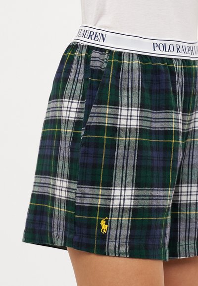 Kárové šortky vyrobené z měkkého materiálu; obsahují zelený, námořnický a bílý kostkovaný vzor s žlutými akcenty a bílým elastickým pasem.