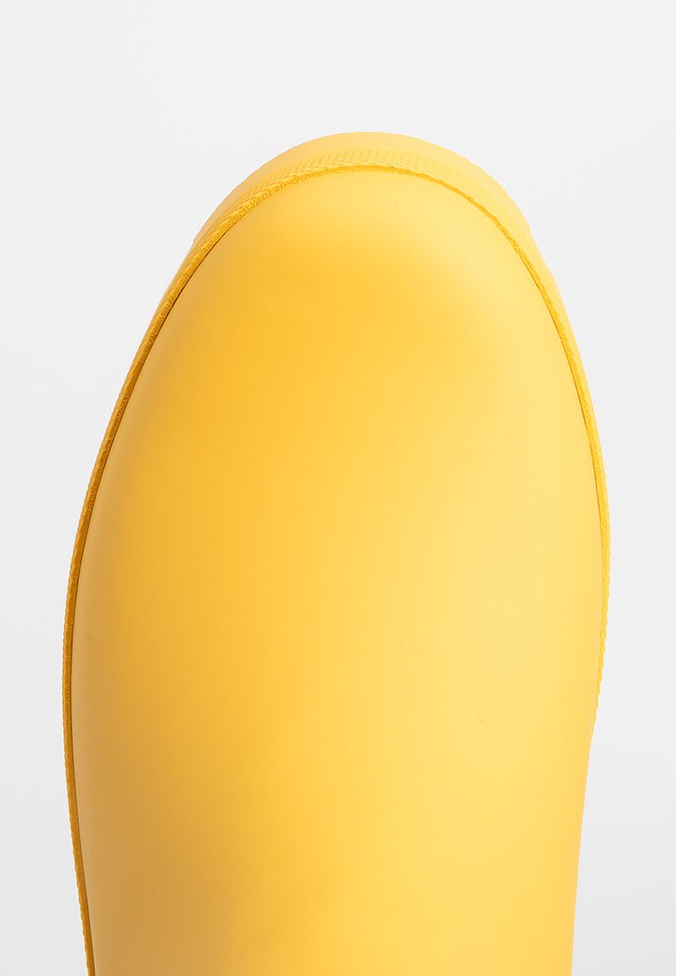Stivale di gomma giallo con finitura liscia e lucida, punta arrotondata e dettagli cuciti lungo il bordo superiore. Adatto per condizioni di bagnato.