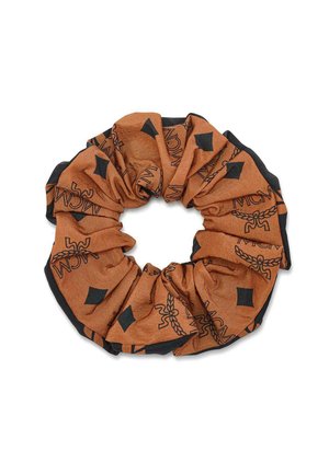 Brun og sort stof scrunchie med MCM-logo og diamantformede mønstre, samlet i en cirkulær form til hårstyling.