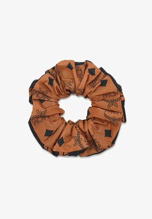Brązowo-czarna gumka do włosów z materiału z logo MCM i wzorami w kształcie diamentów, zebrana w okrągły kształt do stylizacji włosów.
