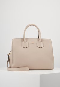 Beżowa skórzana torebka o teksturowanej powierzchni, z dwoma krótkimi uchwytami i odpinanym paskiem na ramię. Posiada minimalistyczne akcenty ze sprzętu oraz usztywniony kształt.