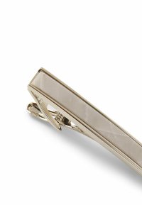 Metalen stropdasclip met een rechthoekig ontwerp, voorzien van een gepolijste lichtgekleurde inleg en glanzende goudkleurige randen. De clipbevestiging is zichtbaar.