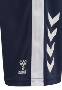 Pantalones cortos deportivos navy con rayas laterales blancas y un patrón en forma de chevrón. Presenta un logo en la parte inferior de la pierna. Tejido suave y ligero.