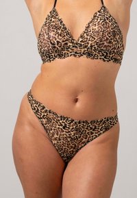 Set di bralette e thong con stampa leopardata, caratterizzato da rifiniture in pizzo, tessuto morbido e coppe triangolari. Entrambi i pezzi presentano un design con bordi ondulati.