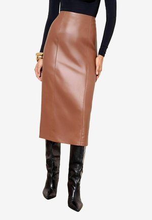 Woman wearing a high-waisted brown leather midi skirt, black long-sleeve top, black knee-high boots, and gold bracelets.