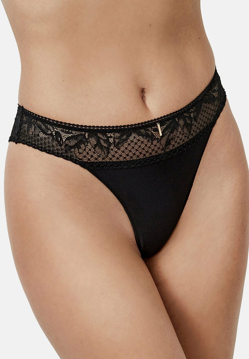 Zwarte kanten string met een bloemenkant tailleband en delicate afwerking. Beschikt over een gladde stof en een subtiele gouden accentdetail.