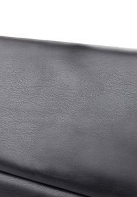 Superficie de cuero texturizado negro, con un ligero patrón de grano y un acabado suave, que resalta su apariencia lisa y duradera.