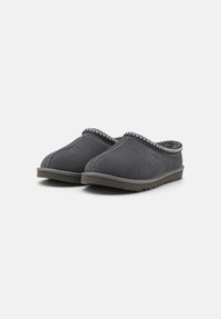 Pantofole in suede grigio con design slip-on, dotate di un bordo cucito a contrasto lungo il bordo superiore e un morbido interno testurizzato.