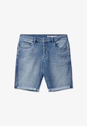 Heledad teksased, kerge sinise värviga, mis on varustatud traditsioonilise viie taskuga, nööbiga kinnituse ja üles keeratud äärega, andes mugava välimuse.