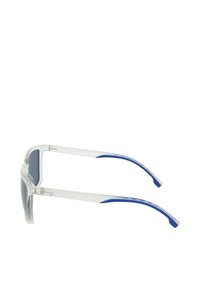 Przezroczyste plastikowe okulary przeciwsłoneczne z ciemnymi soczewkami, z niebieskimi akcentami na zausznikach oraz eleganckim, geometrycznym designem.