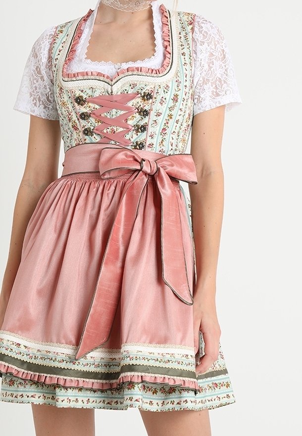 Femme portant une robe traditionnelle avec des motifs floraux, des manches en dentelle, un tablier en satin rose noué en nœud à la taille et des accents décoratifs en dentelle.