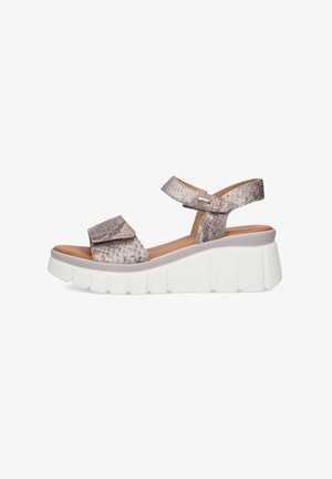 Sandalo con zeppa beige con motivo effetto pelle di serpente, cinturini regolabili alla caviglia e alle dita, suola bianca spessa.