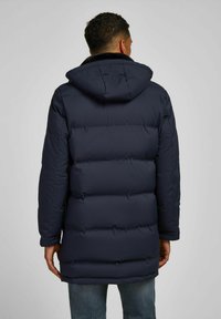 Navyblauwe gewatteerde jas met capuchon, met een doorstikte uitstraling, zichtbare stiksels en een relaxte pasvorm, gemaakt van een soepele, geïsoleerde stof.