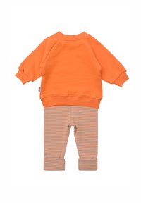 Oranges Sweatshirt mit Raglanärmeln kombiniert mit gestreiften, hellgrauen und orangefarbenen Leggings. Weicher Stoff, lässiges Design und umgeschlagene Bündchen.